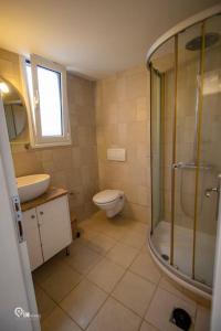 a bathroom with a shower and a toilet and a sink at 'Alexander' Seaside House With View In Nea Makri in Nea Makri