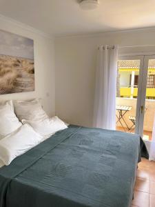 um quarto com uma cama grande e um cobertor azul em El casa KáMa em Denia