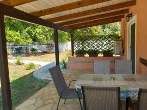 a patio with a table and chairs and a fence at Joleni Cottage in Keramies in Kefallonia