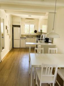 uma cozinha com balcões brancos e uma mesa e cadeiras brancas em El casa KáMa em Denia