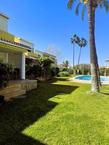 um quintal com palmeiras e uma piscina em El casa KáMa em Denia