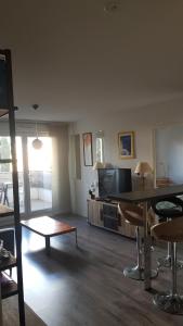 een woonkamer met een tafel en een televisie bij APPARTEMENT T2 AGROPARC AVIGNON in Avignon