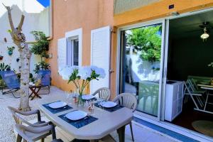 Una mesa blanca y sillas en un patio. en Le MARINE Rez de Jardin direct Plage Parking Privé Climatisé, en Sète 5 fotos más