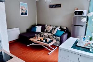 Una sala de estar con un sofá y una mesa de café. en Le MARINE Rez de Jardin direct Plage Parking Privé Climatisé, en Sète