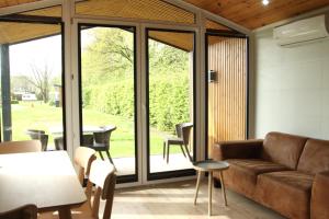 a living room with a couch and a table at Chalet Lodge in Drijber