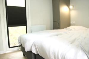 - une chambre avec un lit blanc et une fenêtre dans l'établissement Chalet Lodge, à Drijber