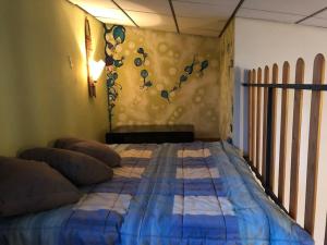 uma cama com um edredão azul num quarto em Loft immerso nel bosco em Rivola