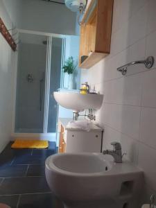 uma casa de banho com um lavatório e um WC. em Loft immerso nel bosco em Rivola