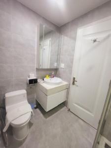 a bathroom with a white toilet and a sink at Scenic Valley 2 in Ho Chi Minh City