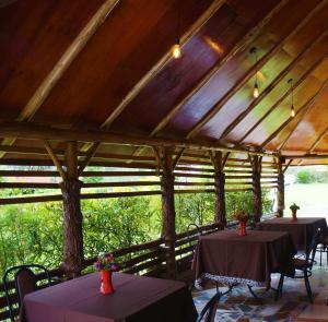 a group of tables in a pavilion with trees at ATACO COUNTRY RESORT in Fort Portal
