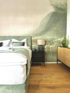 a bedroom with a bed and a painting on the wall at betterplaces: Boutique Apartments - Frontenhausen in Dingolfing