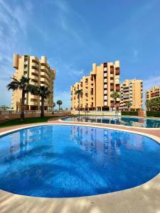 una gran piscina azul con edificios en el fondo en Miradores De La Manga, en San Blas