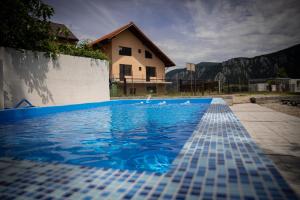 a blue tile swimming pool in front of a house at Pam Dubova Holiday in Dubova