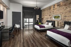 a bedroom with two beds and a brick wall at Hotel Metro in London