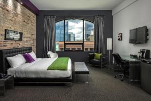 a hotel room with a bed and a desk and a window at Hotel Metro in London