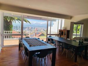 a dining room with a table and chairs and a large window at De Hoop Villa in Cape Town