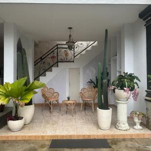 a room with potted plants and a staircase with chairs at Villa Sayong Indah bedugul in Bedugul