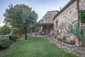 an old stone building with a table and a tree at Wp Relais Pompana Etruscan Villas in Villa Montesoli