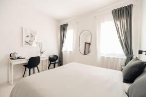 Un dormitorio blanco con una cama y un escritorio. en Cà Zorzi - 2 minutes from Biennale & Canal view - APE G, en Venecia