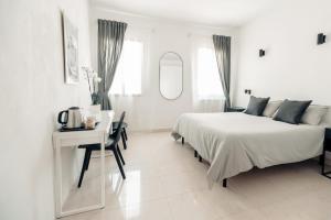 Habitación blanca con cama, escritorio y espejo. en Cà Zorzi - 2 minutes from Biennale & Canal view - APE G, en Venecia