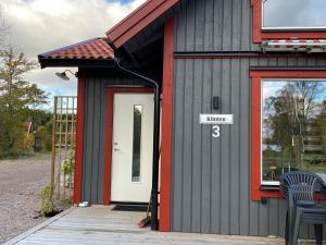 een klein gebouw met een deur en een bord erop bij Joarsbo, Stuga 3, Klinten in Kalv