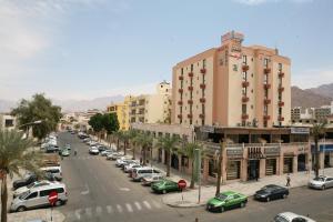 Una calle de la ciudad con muchos coches aparcados en Al Raad Hotel, en Áqaba