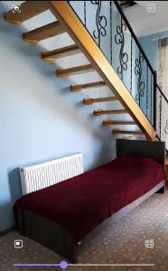a staircase with a red bed under a stair case at Apart townhouse in K'obulet'i