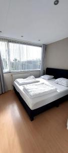 een slaapkamer met 2 bedden en een groot raam bij Plattedijk - vakantiehuis 25-26 in Lemmer