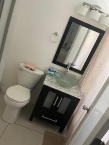 a bathroom with a toilet and a sink with a mirror at Fabulous downtown experience 3 mins away in Las Vegas