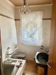 La salle de bains est pourvue d'un lavabo et d'un lustre. dans l'établissement Casa Amelia Noia, à Noia