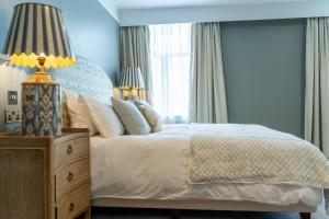 a bedroom with a bed with a blue wall at The Vineyard Hotel in Horsham, Near Gatwick Airport in Horsham +27 photos