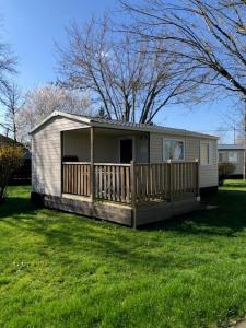 a small house with a porch on a grass field at mobil home o'hara in Poilly-lez-Gien