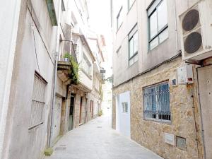 eine Gasse in einer alten Stadt mit Gebäuden in der Unterkunft Sentir Galicia Apartamentos in Redondela
