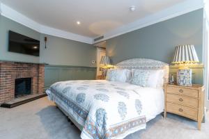 een slaapkamer met een bed en een open haard bij The Vineyard Hotel in Horsham