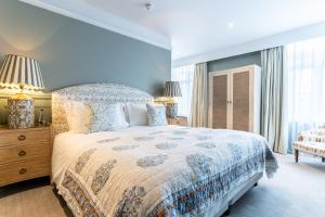 a blue bedroom with a large bed and a window at The Vineyard Hotel in Horsham