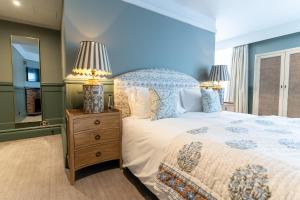 a bedroom with a bed and two lamps on a night stand at The Vineyard Hotel in Horsham