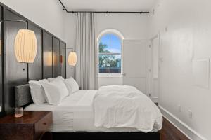 a white bedroom with a large bed and a window at Stay Rafa At 2000 Spruce in Philadelphia