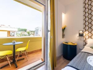 um quarto com uma varanda com uma mesa e uma cama em Le residenze di Carlà - Stampace em Cagliari