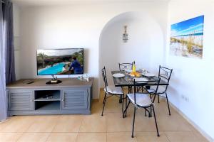 a dining room with a table and a tv at Buena Pesca 27 in Puerto del Carmen