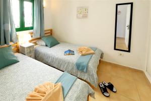 a bedroom with two beds and a mirror at Buena Pesca 27 in Puerto del Carmen