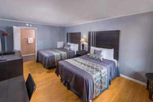a hotel room with two beds and a flat screen tv at Sunrise Inn Hershey in Hershey