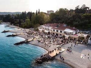 a group of people on a beach near the water at Casa Duilia centro storico in Padenghe sul Garda