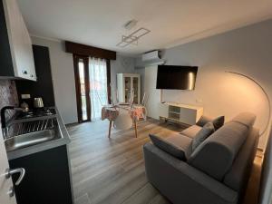 a living room with a couch and a tv in a room at Casa Duilia centro storico in Padenghe sul Garda