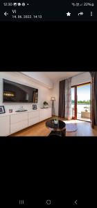 ein Wohnzimmer mit einem TV und einem Couchtisch in der Unterkunft Villa Ivan in Pridraga