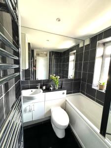 a bathroom with a toilet and a sink and a tub at Modern Flat in Maida Vale in London