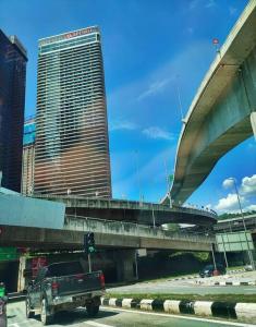 a truck driving down a street with a bridge at KL Marriot Empress Suite Infinity View Apartment- Self Check/In in Petaling Jaya