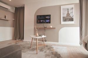 a living room with a table and a tv on the wall at KL Marriot Empress Suite Infinity View Apartment- Self Check/In in Petaling Jaya