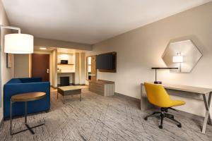 a living room with a blue couch and a yellow chair at Holiday Inn Express & Suites Mobile West I-10 by IHG in Tillmans Corner