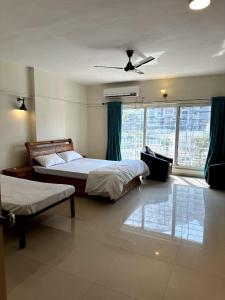 1 dormitorio con 2 camas y ventilador de techo en AP's Castle Stay en Kharadi