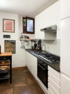 a kitchen with white cabinets and a stove top oven at Your place in San Frediano in Florence